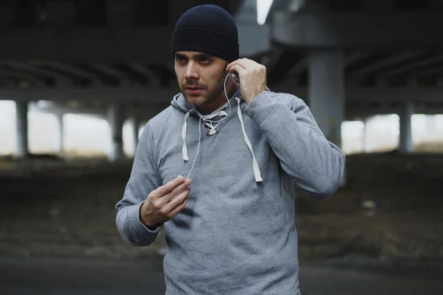 Pria mengenakan hoodie bahan fleece yang tebal dan hangat, diproduksi oleh konveksi Rafsakaos