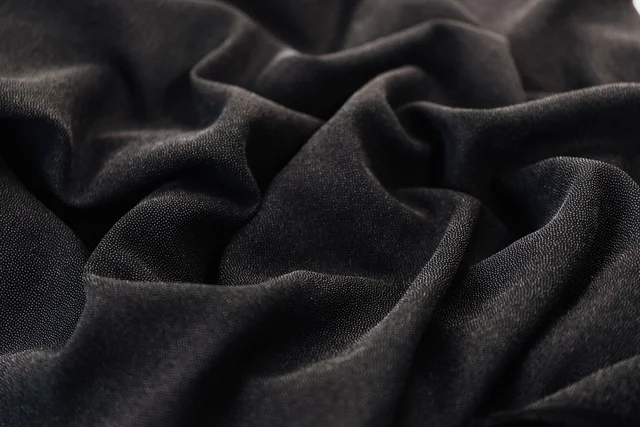 Tekstur kain hitam cotton combed untuk produksi kaos custom warna hitam di workshop Rafsakaos